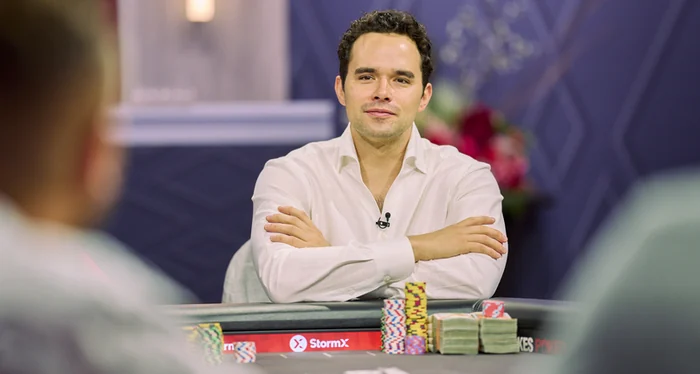 Alan Keating seated with arms folded at a High Stakes Poker table