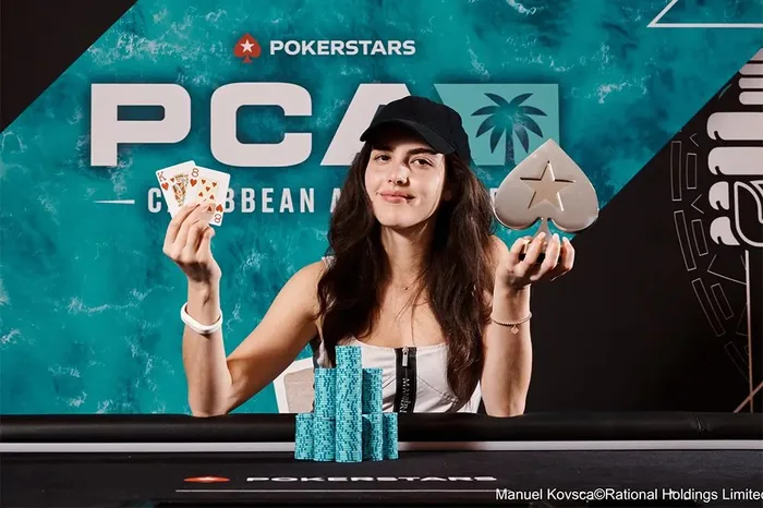 Alexandra Botez holding the PokerStars trophy after winning her first poker tournament at the 2023 PCA