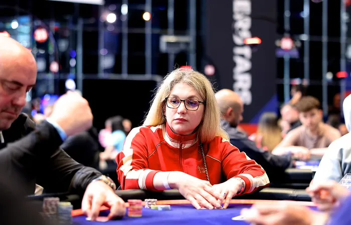Almira Skripchenko at the Poker Table Almira Skripchenko, chess International Master and European Women's Champion, seated at a PokerStars tournament table in a red tracksuit