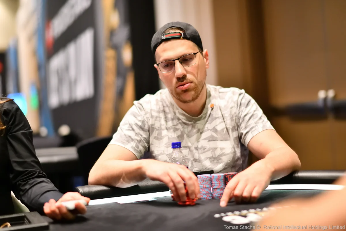 Artur Martirosian between hands at a live tournament Artur Martirosian in a backwards cap and glasses stacking chips at a live tournament table