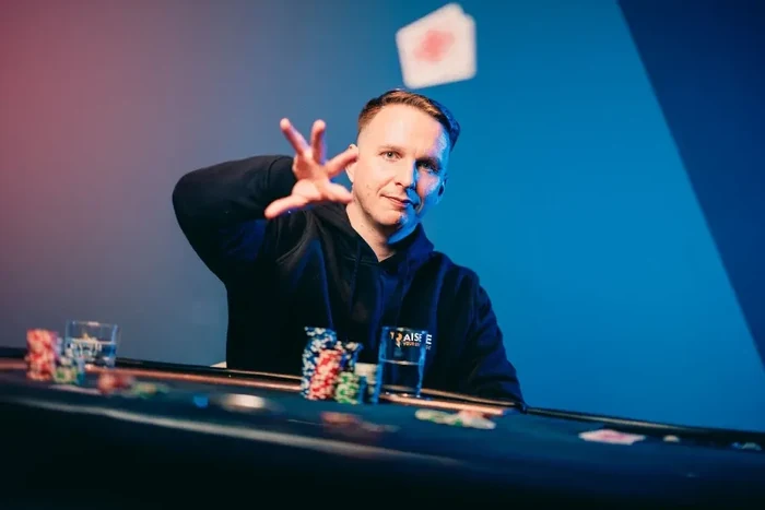 Benjamin Bencb Rolle studio portrait Benjamin Bencb Rolle throwing a playing card at a poker table under blue studio lighting
