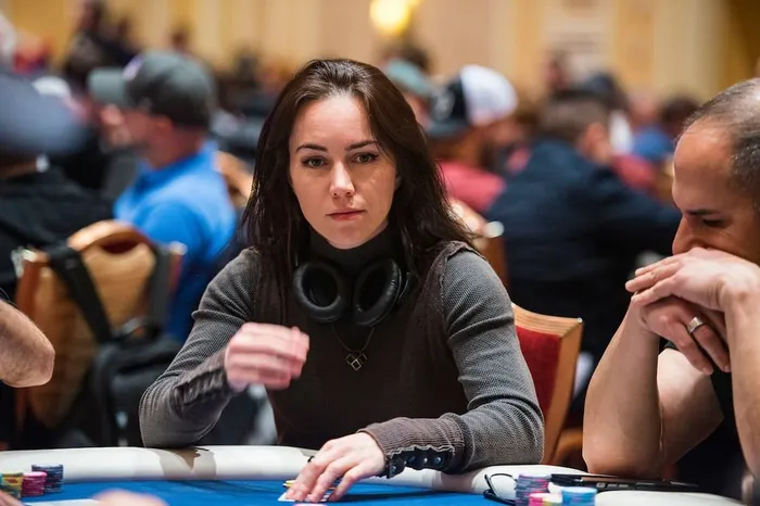 Liv Boeree competing in a live poker tournament Liv Boeree competing in a live poker tournament with headphones around her neck