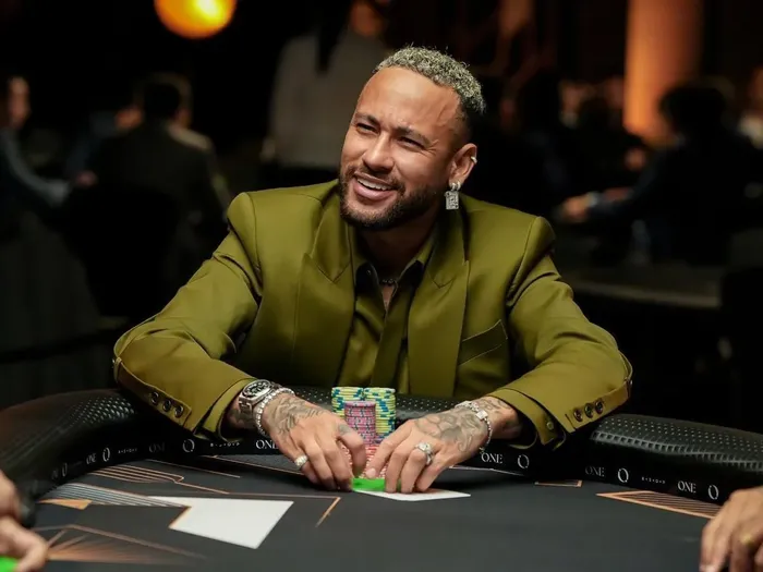 Neymar Jr at a live poker event Neymar Jr at a poker table with chips stacked in front of him
