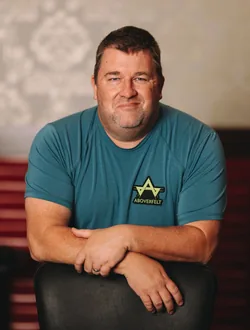 Chris Moneymaker Quick Facts Headshot Chris Moneymaker seated with arms folded over a chair back at a poker room