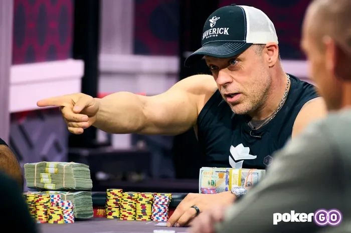 Eric Persson pointing across the table during a high-stakes cash game with bundles of cash behind his chips