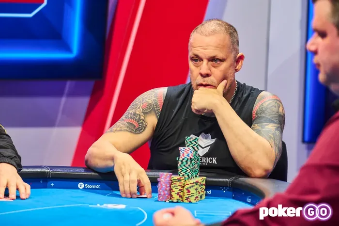Eric Persson deep in thought at a PokerGO televised cash game with chips stacked in front of him
