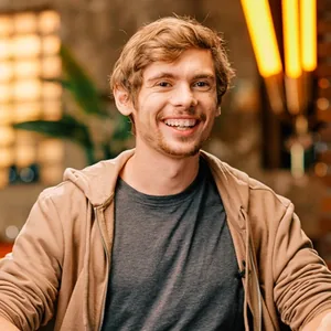 Fedor Holz smiling at a poker table in a studio setting