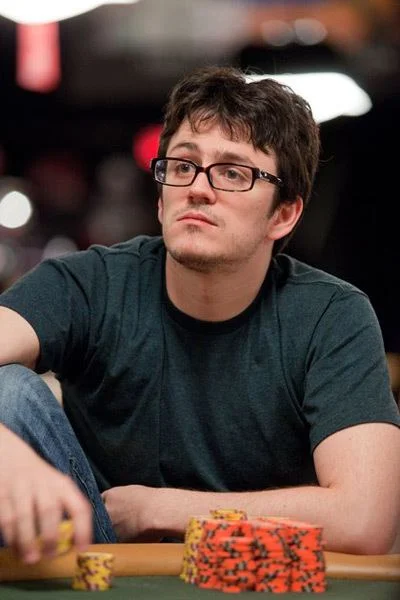 Isaac Haxton Poker Player Portrait Isaac Haxton seated at a poker table wearing glasses