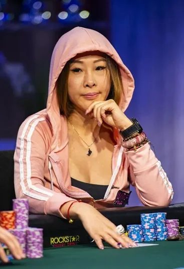 Kitty Kuo at a poker tournament wearing a pink hoodie with poker chips