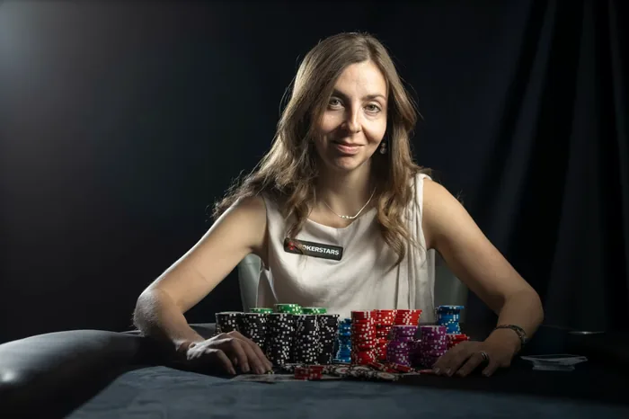 Maria Konnikova PokerStars studio portrait Maria Konnikova behind stacks of tournament chips in a PokerStars studio portrait