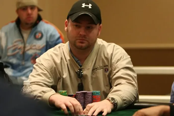 Mike Postle sitting behind a stack of chips at a live tournament table