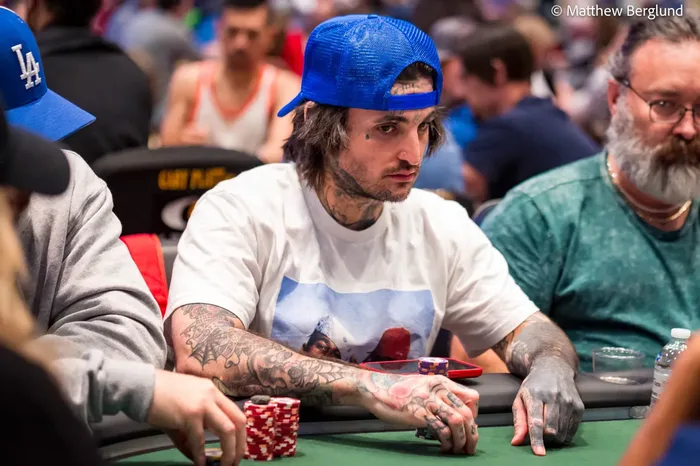 Mikki Mase wearing a blue cap at a poker tournament table with chips