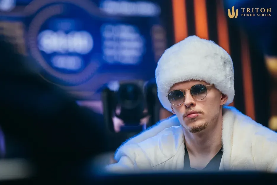 Ossi Ketola wearing a white fur hat and sunglasses during a Triton Poker Series heads-up session