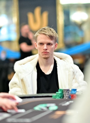 Ossi Ketola at a Triton Poker high-stakes cash game table wearing a white fur coat