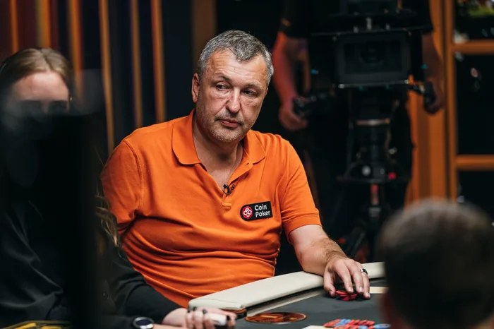 Tony G wearing an orange CoinPoker polo shirt at a televised cash game table