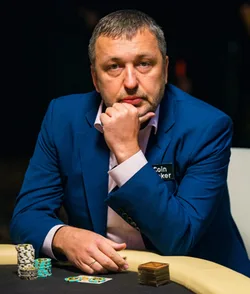 Tony G wearing a blue suit with CoinPoker branding at a poker table with chips