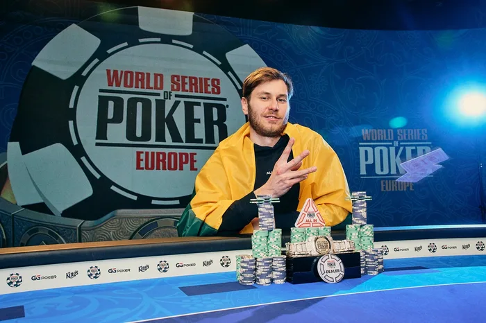 Kudzmanas Third Bracelet WSOPE Prague 2026 Marius Kudzmanas holds three fingers up for his third WSOP bracelet with chips and the gold bracelet on the table at WSOP Europe Prague