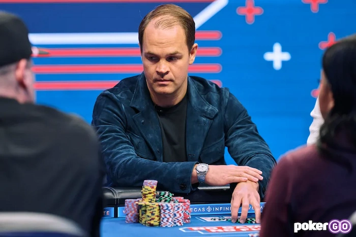 Andrew Robl, high-stakes cash game specialist, focused at the PokerGO table in blue velvet jacket, hands on rail with stacked chips during a live super high-roller session.