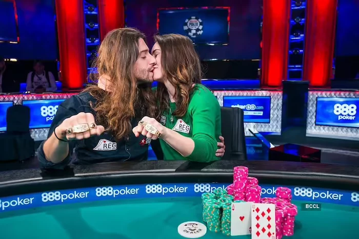 Liv Boeree and Igor Kurganov, WSOP Tag Team Event champions, sharing a celebratory kiss at the poker table while displaying their matching WSOP bracelets.