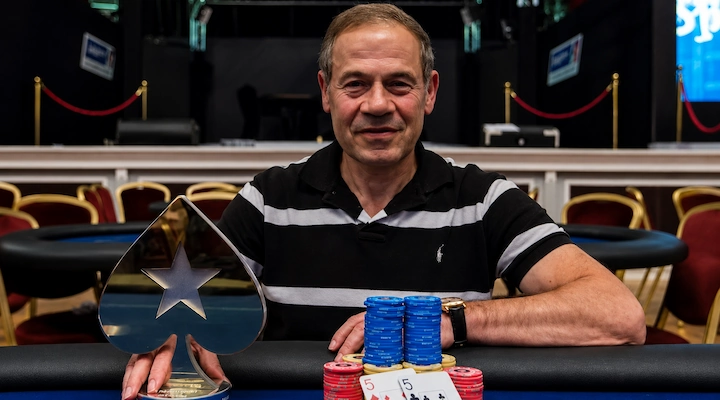 Isai Scheinberg, founder of PokerStars, holding a PokerStars trophy at a poker tournament